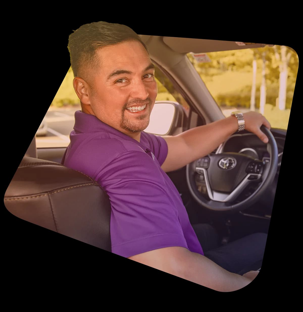 A Bonvia driver in a branded polo, smiling from the driver's seat.